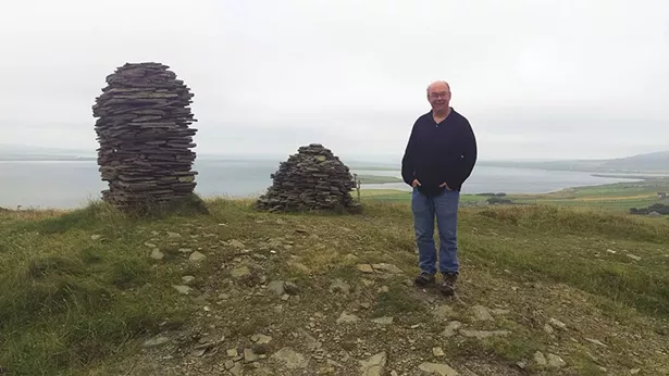 Laird Scranton with cairns atop Cuween Hill in the Orkney Islands off Scotland.