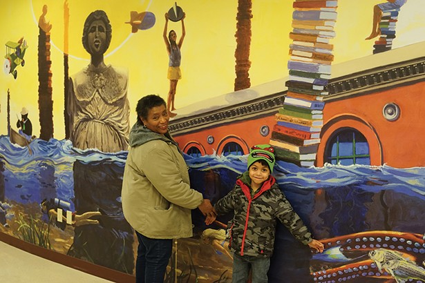 April Coal Blocker and Banicio Sanchez, in front of a mural by James Ransome at the Adriance Memorial Library. - PHOTO BY JOHN GARAY