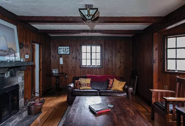 Stewart has filled the wood paneled den - with art and mementos from her parents and - grandparents. The paned leaded glass window - and Art Deco chandelier are original to the home. “This really does remind you of an old library,” she says. “It’s been nice to introduce things from my family. It gives the space a very warm feeling.” - PHOTO: DEBORAH DEGRAFFENREID