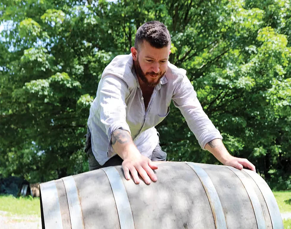 Todd Cavallo rolls a barrel into the yard to use as a tasting table. - PHOTO: PETER BARRETT