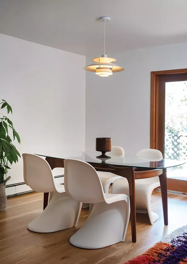 The dining room features a glass dining table designed by furniture designer-turned-shipbuilder Adrian Pearsall, Verner Panton single-injection plastic chairs, and a Louis Polson PH-5 pendant lamp. “We love the personalities of the designers from that era and the stories about their projects and artistic endeavors. They were all renaissance people,” says Davis. - PHOTO: DEBORAH DEGRAFFENREID