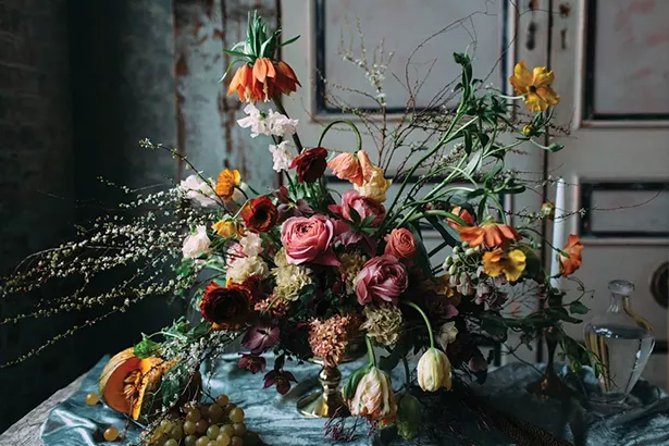 Moody spring floral design by Dark + Diamond, inspired by the Dutch masters. Including blooming spirea branches, fritillaria, parrot tulips, butterfly ranunculus, hyacinth, hellebore and jasmine vines. - COURTESY OF DARK + DIAMOND