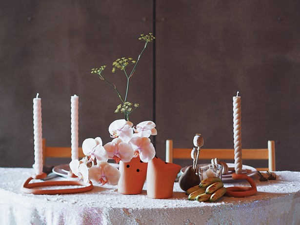 A centerpiece of fennel, orchids, and poppy pods by Heart & Soil.