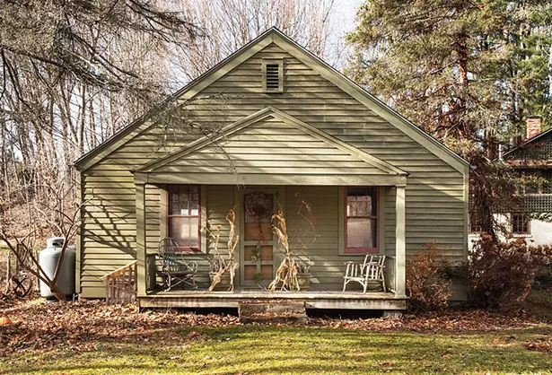 The front porch of the property’s original structure, once a summer cottage, looks across the road to preserved wetlands. “The amount of - time I’ve been up here has just flown by,” Feinberg says. “When I think about it, I’ve really accomplished a lot up here.” - PHOTO: DEBORAH DEGRAFFENREID