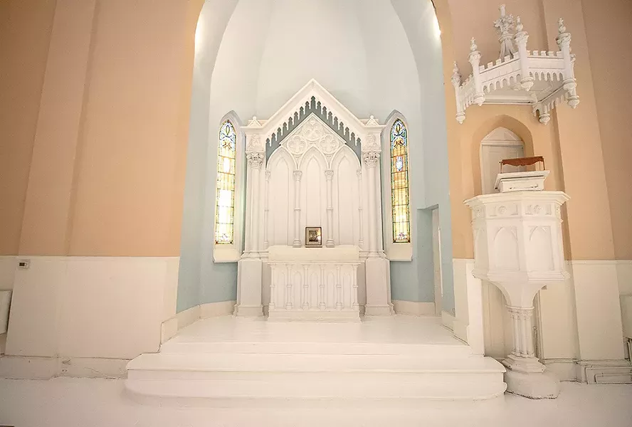 In redesigning the space Bokaer left the church’s original sanctuary and pulpit intact. “I wanted - to keep everything very respectfully as it was,” Bokaer says. With original stained glass windows on either side, the gothic style reredos—the carved centerpiece directly behind the altar—features columns topped with busts of St. Matthew. The crowned pulpit occasionally doubles as a DJ booth. - PHOTO BY SETH DAVIS