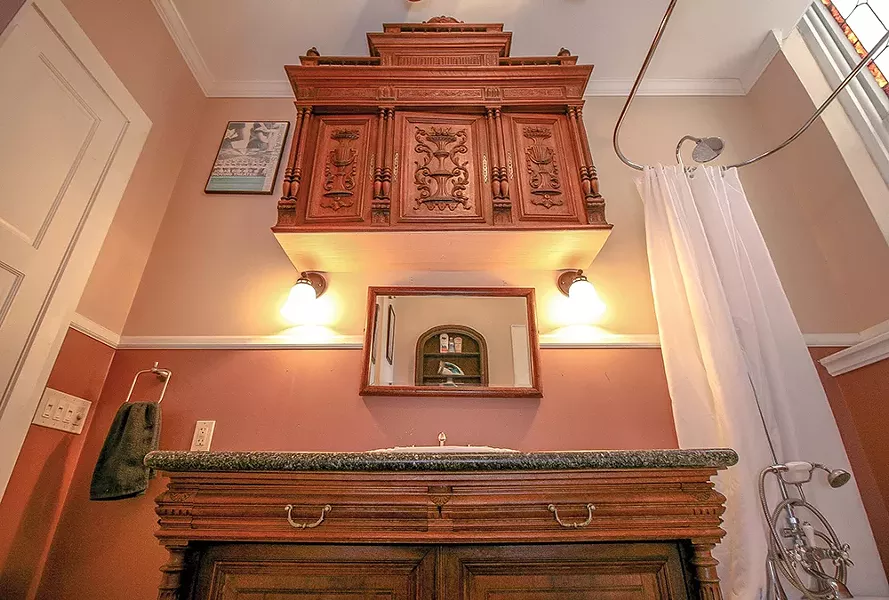 The Previous owners added a full bathroom in - the back corner of the church’s former nave. - Gothic revival style cabinetry as well as granite - countertops were sourced from local Hudson antique shops and vendors. - PHOTO BY SETH DAVIS