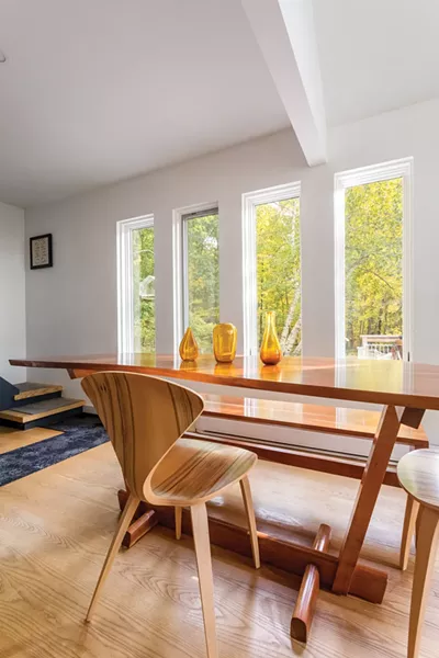 The couple removed a wall between the living room and dining area to open the downstairs and then commissioned their unusually shaped dining table from an artisan in Philadelphia. They also lined the stairs between the two floors to make it easier for their dogs to go up and down. - WINONA BARTON-BALLENTINE