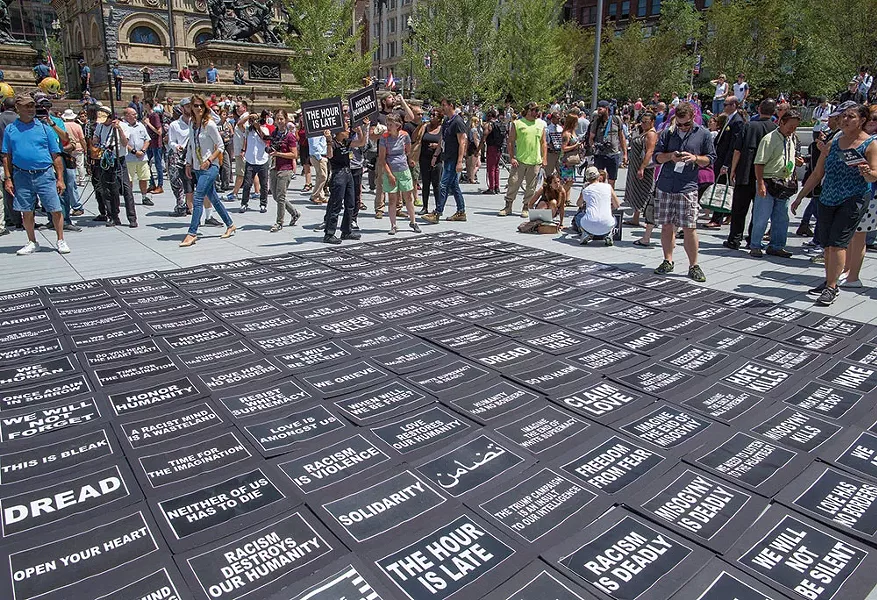 Anti-Trump Democrats encouraged bystanders to pick up message placards and to carry them throughout the park and into surrounding streets. Many of the messages were biblical in tone. - FRANK SPINELLI