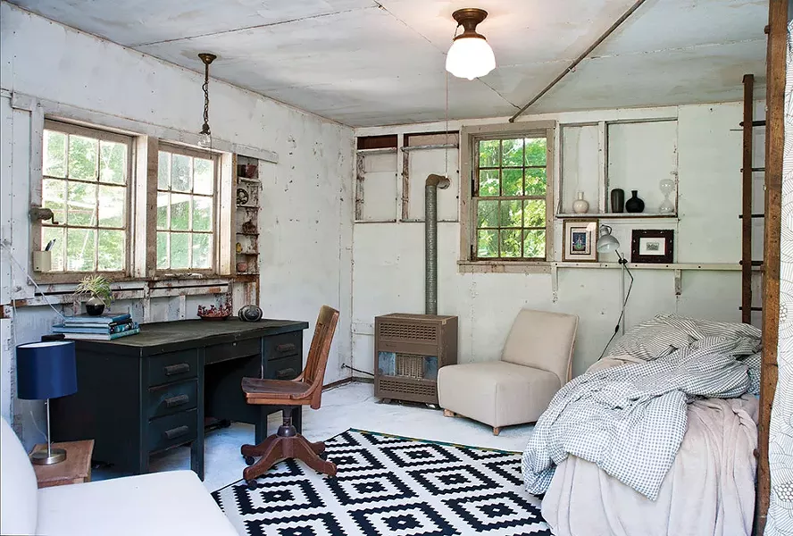 "By the time we got to rennovating this space, I was done painting for the year, so we just left it alone," Sexton says. The ladder-like former wood beam holders now frame an extra bed. "I spend a lot of time out here in summer and even sleep here when it's hot." - DEBORAH DEGRAFFENREID