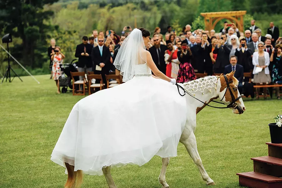 Meryl Gordon rides her horse Lucky down the aisle on her parents's horse farm, High & Mighty Stables, in Ghent on May 21, 2016. - JESSE TURNQUIST