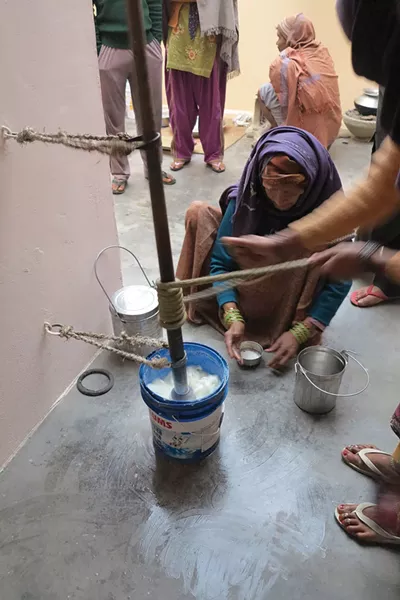 Traditional buttermaking in India uses a system of ropes to spin a center pole that churn water buffalo milk.