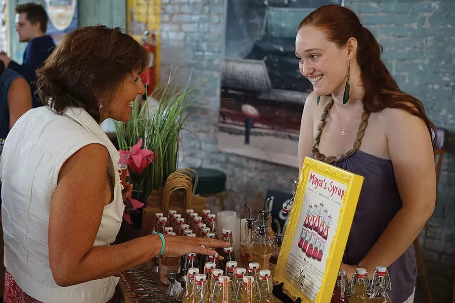 Maya MacLaughlin of Maya’s Jams speaks with a guest about her syrups. - JOHN GARAY