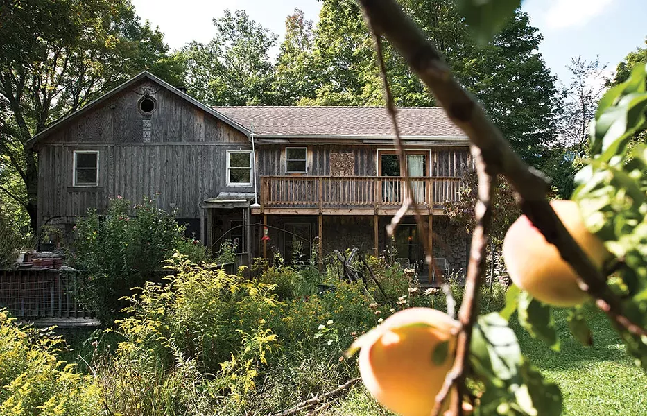 The Perrin family home from the back garden. The original home dates from the 1890s and has been extensively renovated since the family moved almost 20 years ago. The wood carvings along the sides of the house were created by Bryan Perrin. - DEBORAH DEGRAFFENREID
