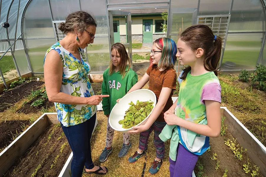 Students in the Oakwood school greenhouse work with a Poughkeepsie Farm Project educator.