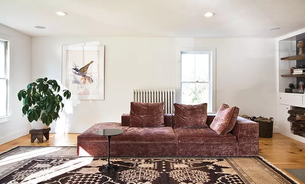 Previous owners had extended the home’s original living room by eight feet. Quatrefoil helped Von Stoddard redesign the space to include built-in bookshelves, a cut out for wood storage, and a wood stove. - DEBORAH DEGRAFFENREID