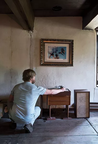 Jeffrey Doornbos with a vintage record player, owned by the home’s previous occupant and then bought back by the couple from a local antique store. - DEBORAH DEGRAFFENREID