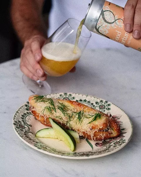 The Maker hot dog on a baguette topped with gruyere, dill & hot mustard.