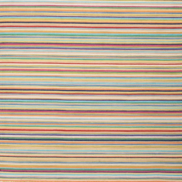 A reversible handmade flat-weave wool rug in cheerful and colorful thin stripes from Burkleman in Cold Spring