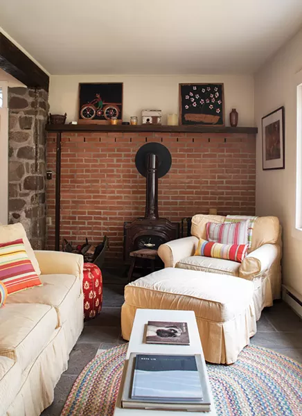 Former owners added a wood stove to the - downstairs “great room.” Stewart has surrounded the space with cozy chairs to create a nook for reading or guests. Since buying the house, she’s had many friends - move to the area, and befriended many locals. - PHOTO: DEBORAH DEGRAFFENREID