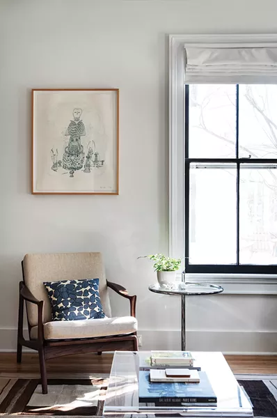 A corner nook of Walker’s downstairs living room was created by closing up an extra kitchen door. The sketch above the chair is a limited-edition print Walker bought in Brooklyn. One particular task she loves is - helping clients hang art. “I think it’s something I’m very skilled at. People often don’t know how to hang work or the right space to hang it. Sometimes beautiful pieces - are hidden away somewhere,” she says. - PHOTO: DEBORAH DEGRAFFENREID