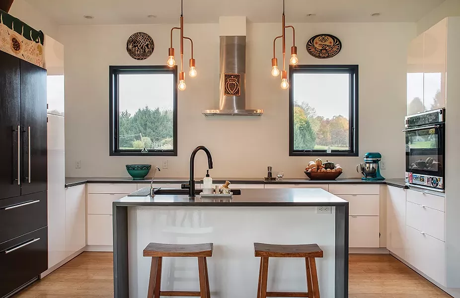 The kitchen, under two west-facing windows. The couple designed the home to have smaller windows along the west side of the house to protect from the warmer afternoon sunlight and keep the home cooler. - PHOTO: DEBORAH DEGRAFFENREID