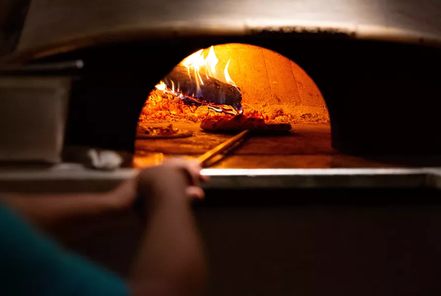 The wood-fired oven imported from Naples maintains a temperature of 800 degrees. A typical pizza take two minutes to cook. - LINDSAY TALLEY