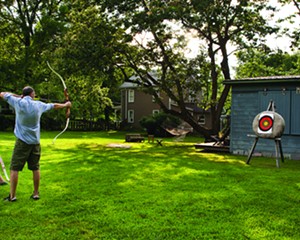 Christina Osburn and Paul O'Connor practicing archery in their backyard.