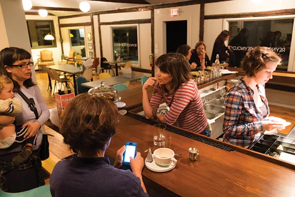 Owner Megan Reynolds chats with customers at the bar of the recently opened tap room and bottle shop Reynolds & Reynolds in Woodstock. Some say the bar’s secret weapon is its 14-foot-long shuffleboard table, pictured against the front window.