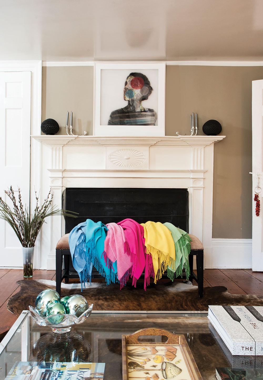 The living room fireplace with a rainbow of shawls. Alpaca fur naturally ranges in 22 different shades. After separating out the guard hair and spinning the fur into yarn, Adams dyes it then weaves it into her signature warm, ultra-soft knit. - DEBORAH DEGRAFFENREID