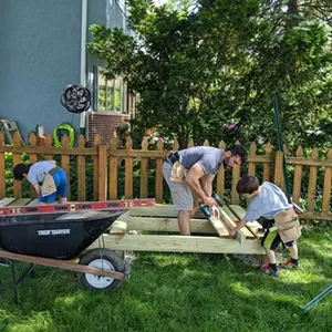 A father and two sons building a wood shed from a Glenn's Sheds plan