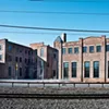 The former US Curtain Factory. Once a thriving manufacturing center, in 2013 the building was converted into 55 units of affordable artist housing; including studios, one-, two-, and three-bedroom units with varying layouts, as well as share-studio and gallery spaces. The former US Curtain Factory. Once a thriving manufacturing center, in 2013 the building was converted into 55 units of affordable artist housing; including studios, one-, two-, and three-bedroom units with varying layouts, as well as share-studio and gallery spaces.