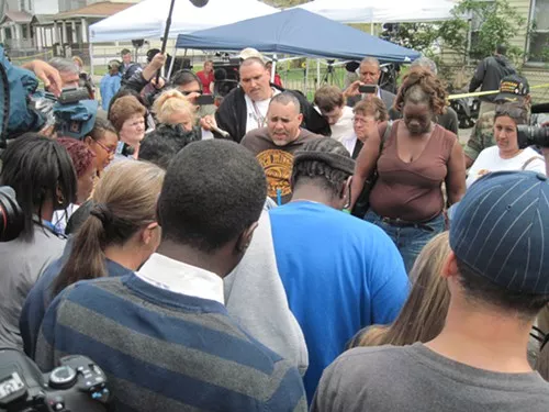 Angel Lozada leads the crowd in a prayer vigil May 8 on Seymour Avenue.