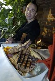 Dina Tsarnas, with what may be the world's largest pork chops. - WALTER NOVAK