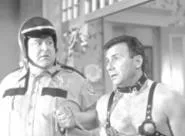 Lech on a leash: Paul Reiser, chained to John - Goodman.