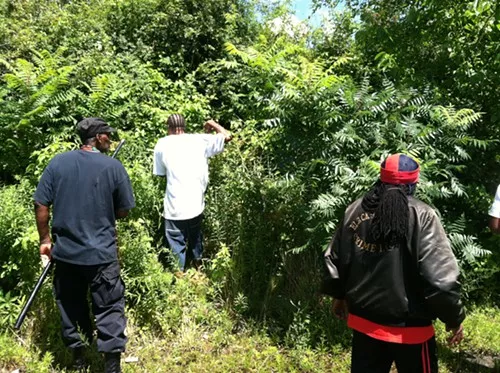 Men scour the woods behind an East Cleveland civic center July 24. Men scour the woods behind an East Cleveland civic center July 24.