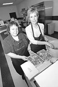 Michelle Gaw (left, with customer Pahy Moran) takes - the misery out of making dinner. - WALTER NOVAK