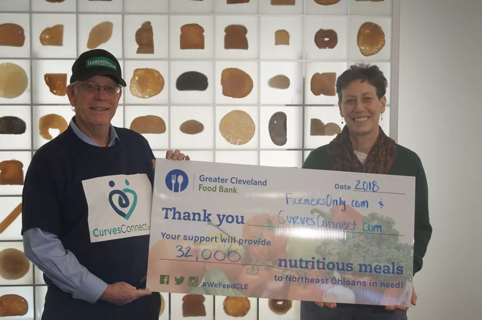 Jerry Miller (left) delivering the Cleveland Food Bank donation check. - PHOTO BY SAM ALLARD