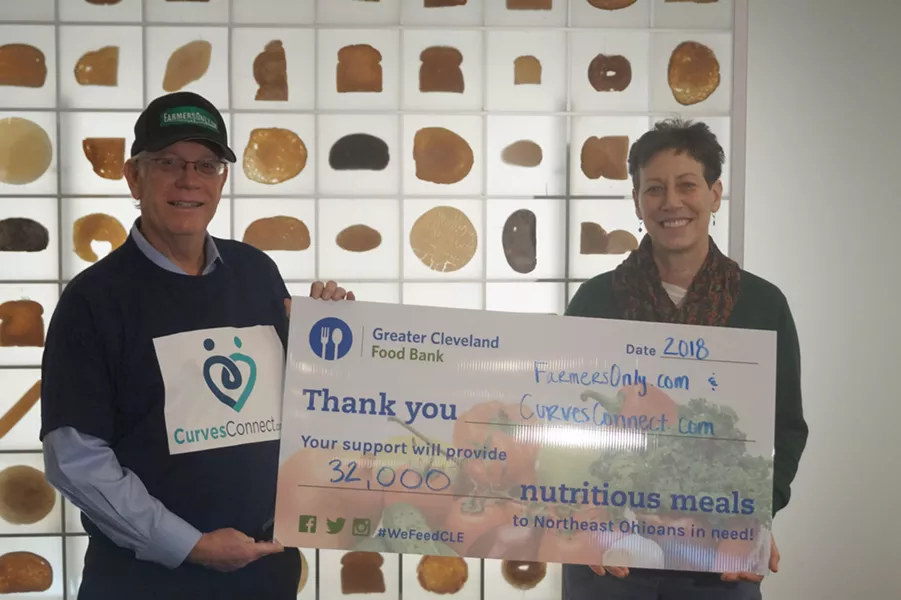 Jerry Miller (left) delivering the Cleveland Food Bank donation check. - PHOTO BY SAM ALLARD