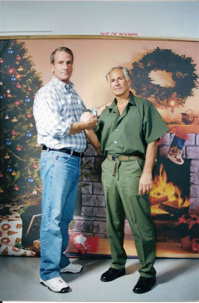 GREETINGS FROM PRISON: John Flahive and George Martorano pose for a holiday photo in front of a faux domestic backdrop at Coleman prison. - COURTESY JOHN FLAHIVE