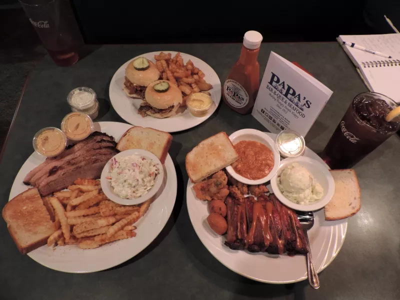 Clockwise from top: BBQ-on-2-buns w/Cajun fries, Ribs & Fried Oysters Combo w/potato salad & Brunswick Stew, Smoked Beef Brisket Platter w/ Cajun fries & slaw