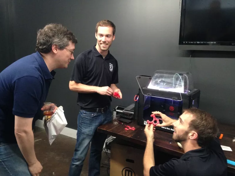 Software engineer James Sentman (l.) gets a few pointers on 3D printing from Maven Makers Tim Cone (center) and Ty Donaldson during a lunchtime workshop.