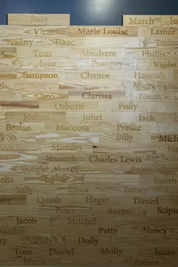 The wall of names of verified enslaved persons who worked in the Owens-Thomas House over the years. - PHOTO BY GEOFF L. JOHNSON