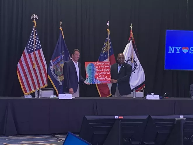 Mayor Van Johnson presents New York Gov. Andrew Cuomo with his own Panhandle Slim portrait, featuring his quote: “A governor can be a very good friend to the people. A governor can be a formidable force.”
