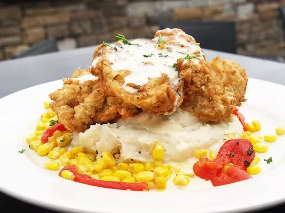 Executive chef Lawrence Rice borrows his recipe for fried pork chops and garlic corn succotash from his grandmother, serving it up with seasoned mashed potatoes.