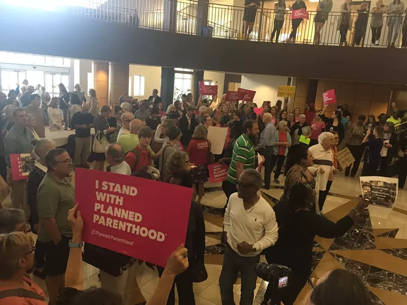 The overflow crowd in the lobby waits in vain for Carter to exit via that route following the meeting