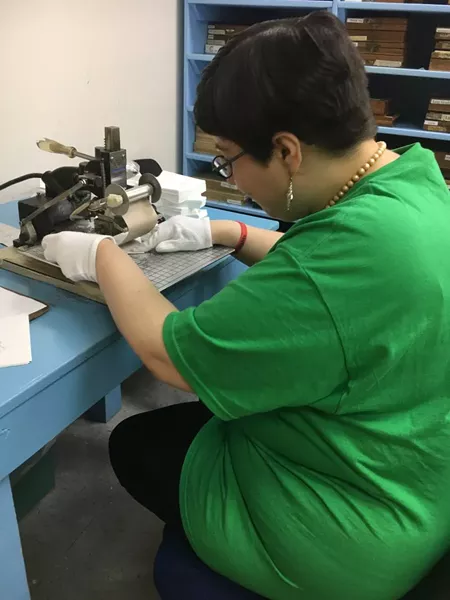 Amber Alana Purdy hand-embosses napkins at the center’s print shop.