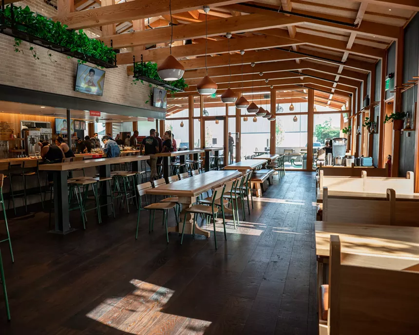 Skylights allow rays of sunshine inside the barbecue hall, highlighting the minimalist style and natural wood tones. - ALISON MCLEAN