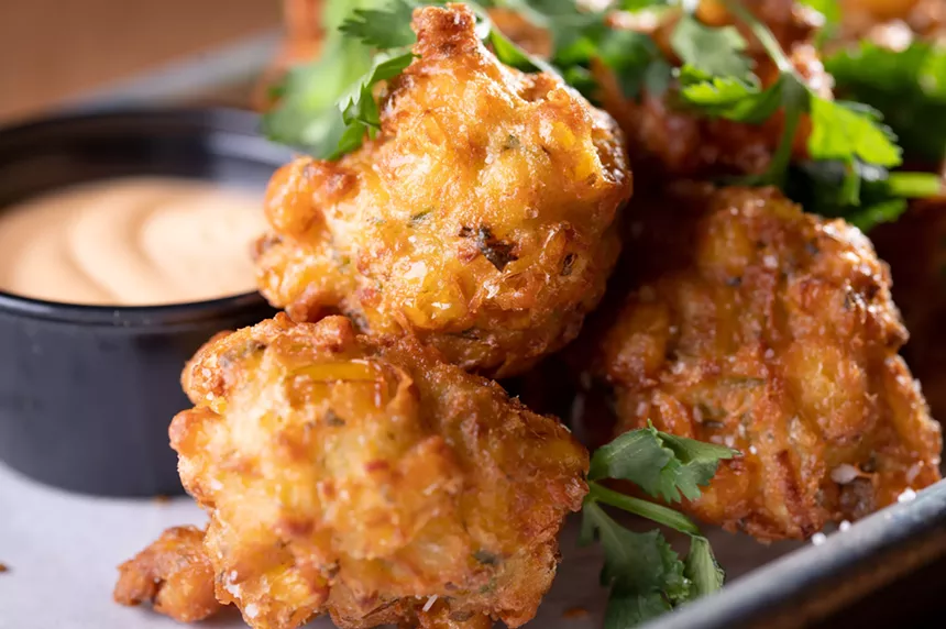 Crunchy corn fritters have sweet whole kernels of corn and are served with a spicy a Sriracha aioli. - ALISON MCLEAN