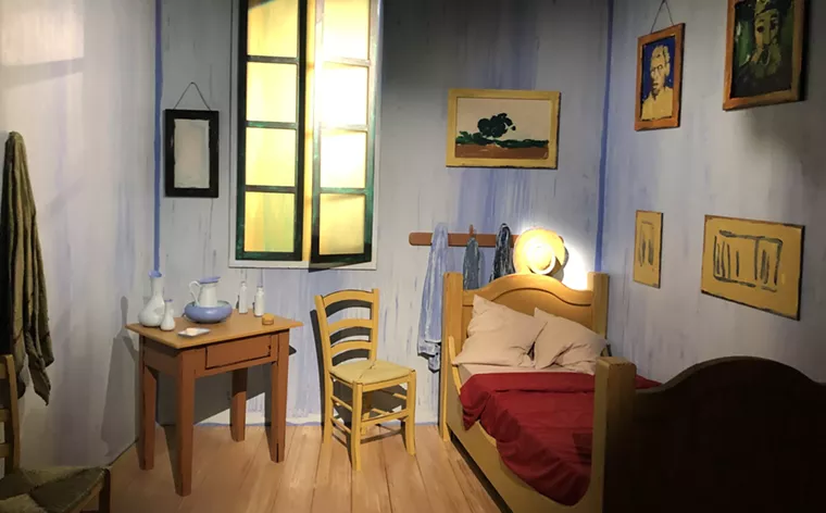 Visitors can step into and take an Instagram-friendly photo on the bed in "The Bedroom at Arles." - PHOTO BY BOB RUGGIERO