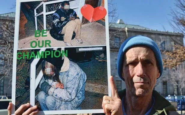 An advocate for Homeless United for Change holds a photo of homeless residents who resorted to living on the streets after the Springfield Overflow Shelter closed it doors. - PHOTO BY JACQUELINE MUHAMMAD